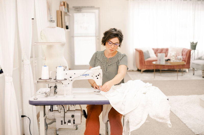 Nadine, A seamstress working diligently at a sewing machine in a bright studio