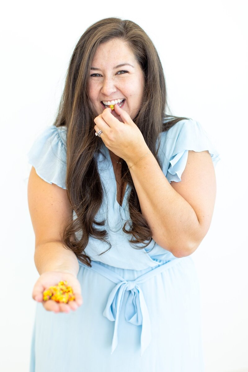 Taylor smiling, holding a hand full of popcorn