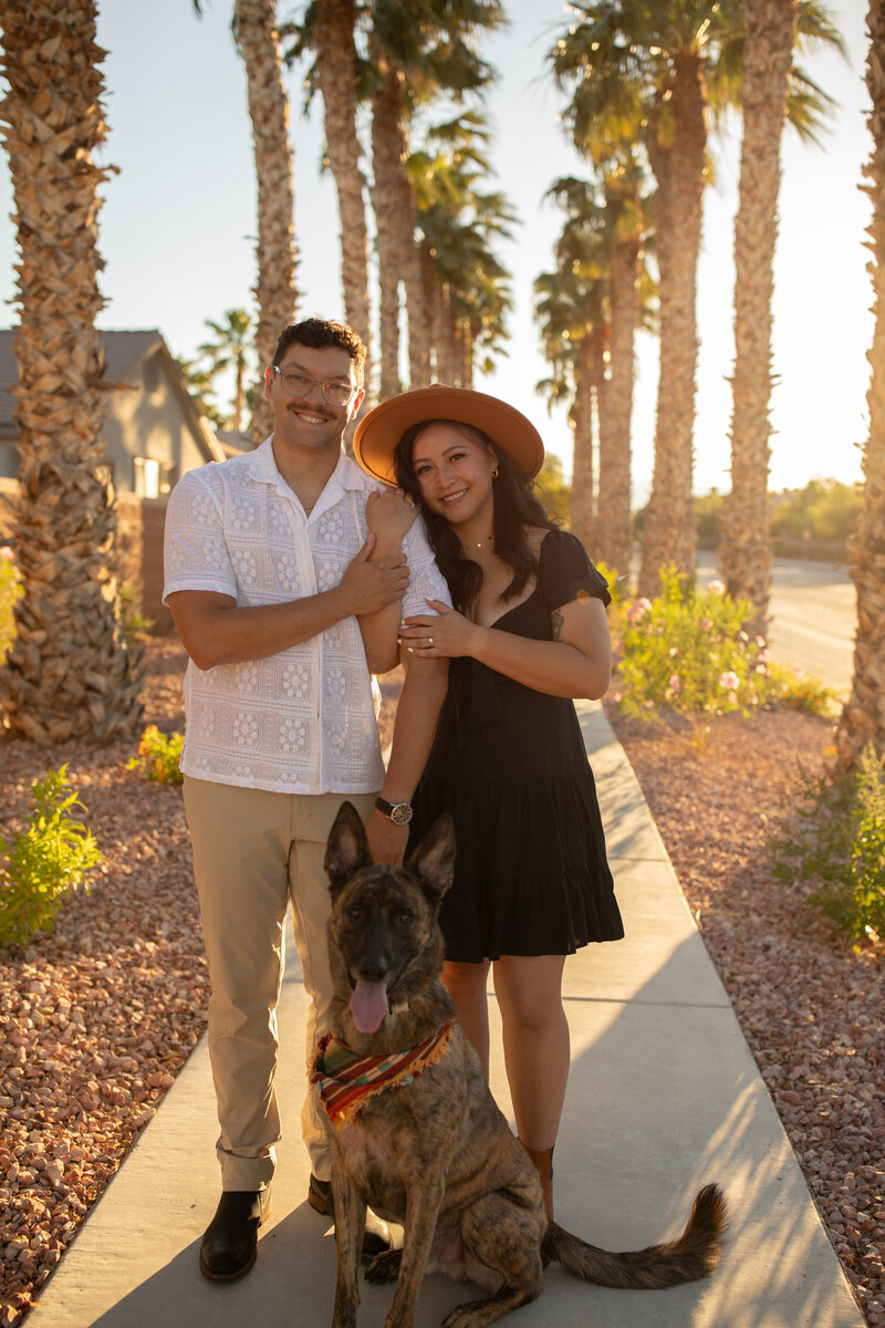 husband and wife with their dog at sunset for an anniversary session  with alexis dean phtography