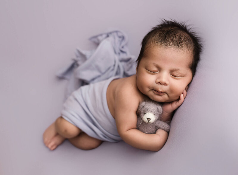 newborn boy holding teddy bear, photographed in Atlanta
