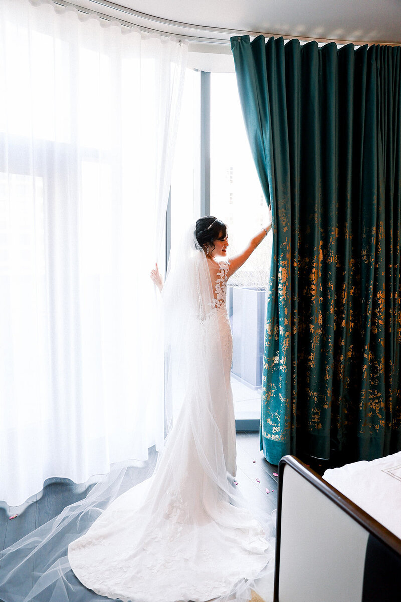 bride looking through blinds