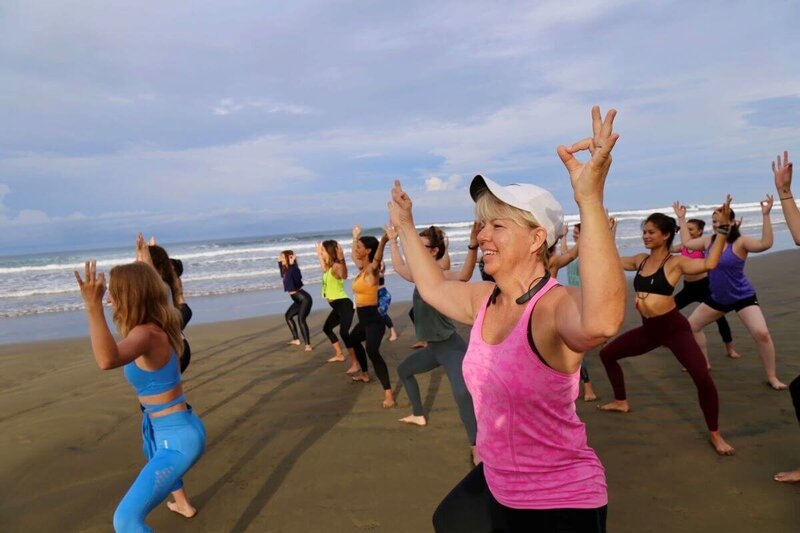 Beach class with students practicing goddess pose during yoga instructor training in Costa Rica