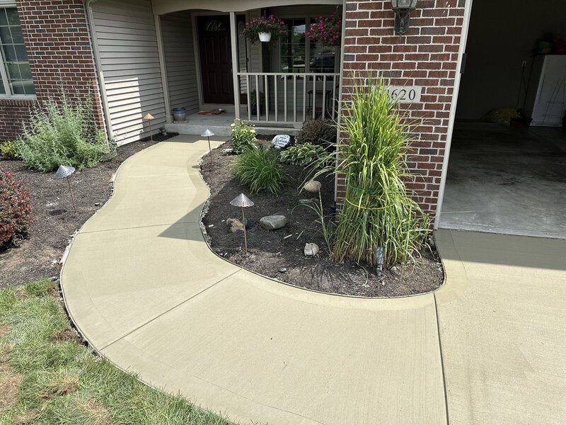 Curved concrete front walkway leading to a porch in Bristol, IN