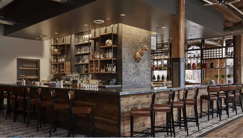 Concrete countertop in upscale but rustic hotel lobby bar with brick,  reclaimed wood and leather accents