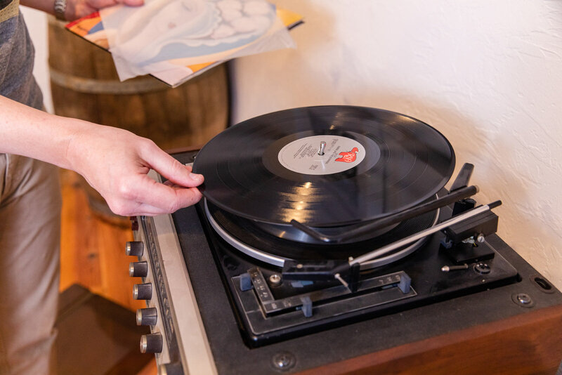 detail of hand putting on a vinyl record disc during branding photo session by laure photography