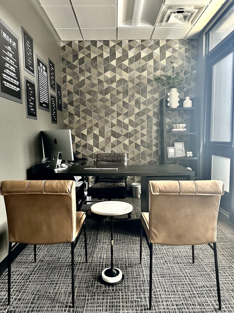 Light brown chairs a dark desk and a playful wallpaper.