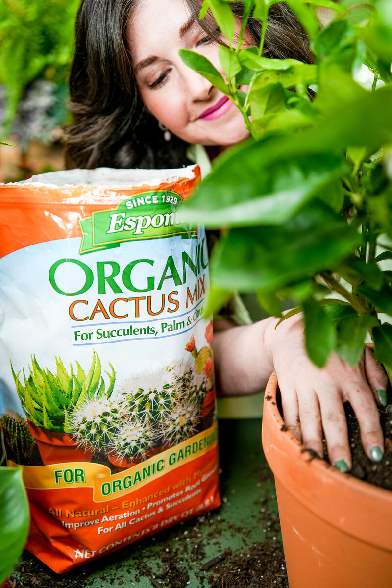 Woman potting plants with Espoma cactus mix and fertilizer