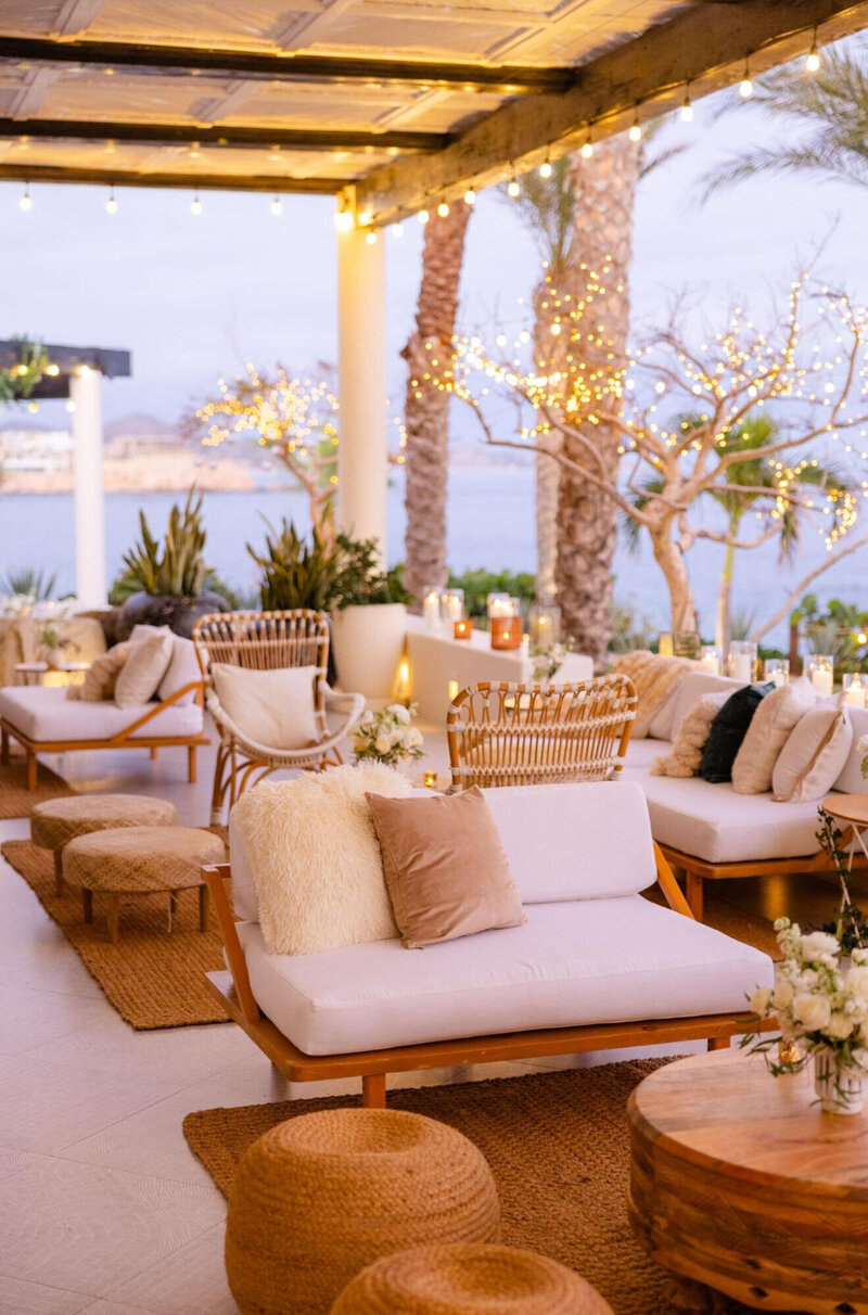 An elegantly lit patio setting with natural furniture