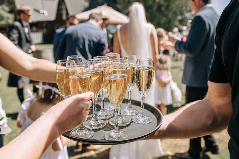 part time tenders staff hand out champagne after wedding in akaroa