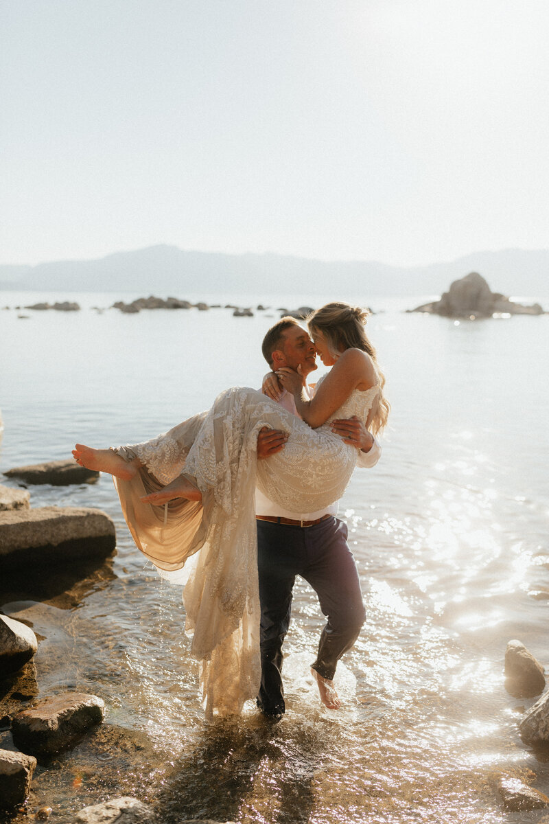 bride and groom walking out of the cold october lake tahoe water, in celebration of getting married