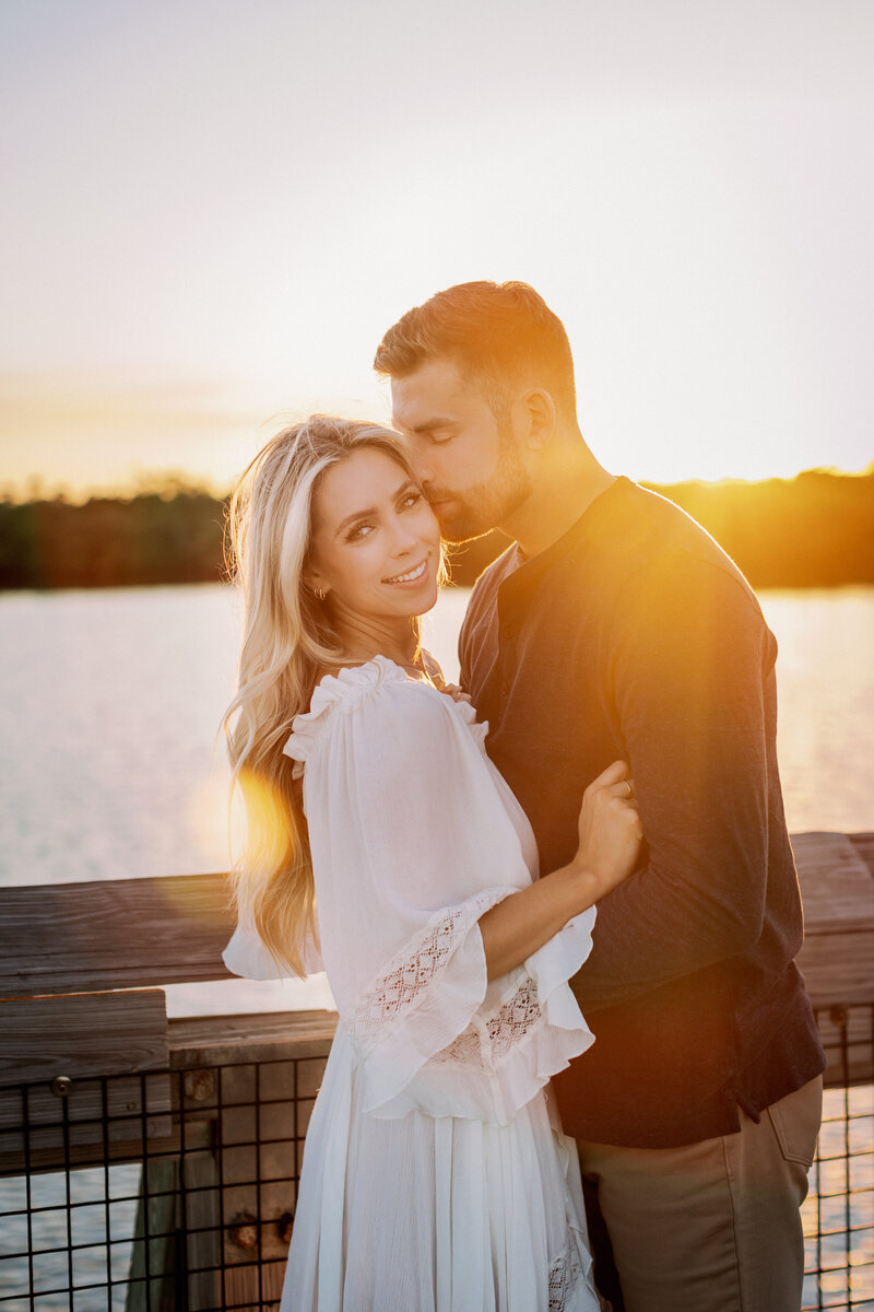 couple snuggling and kissing at sunset