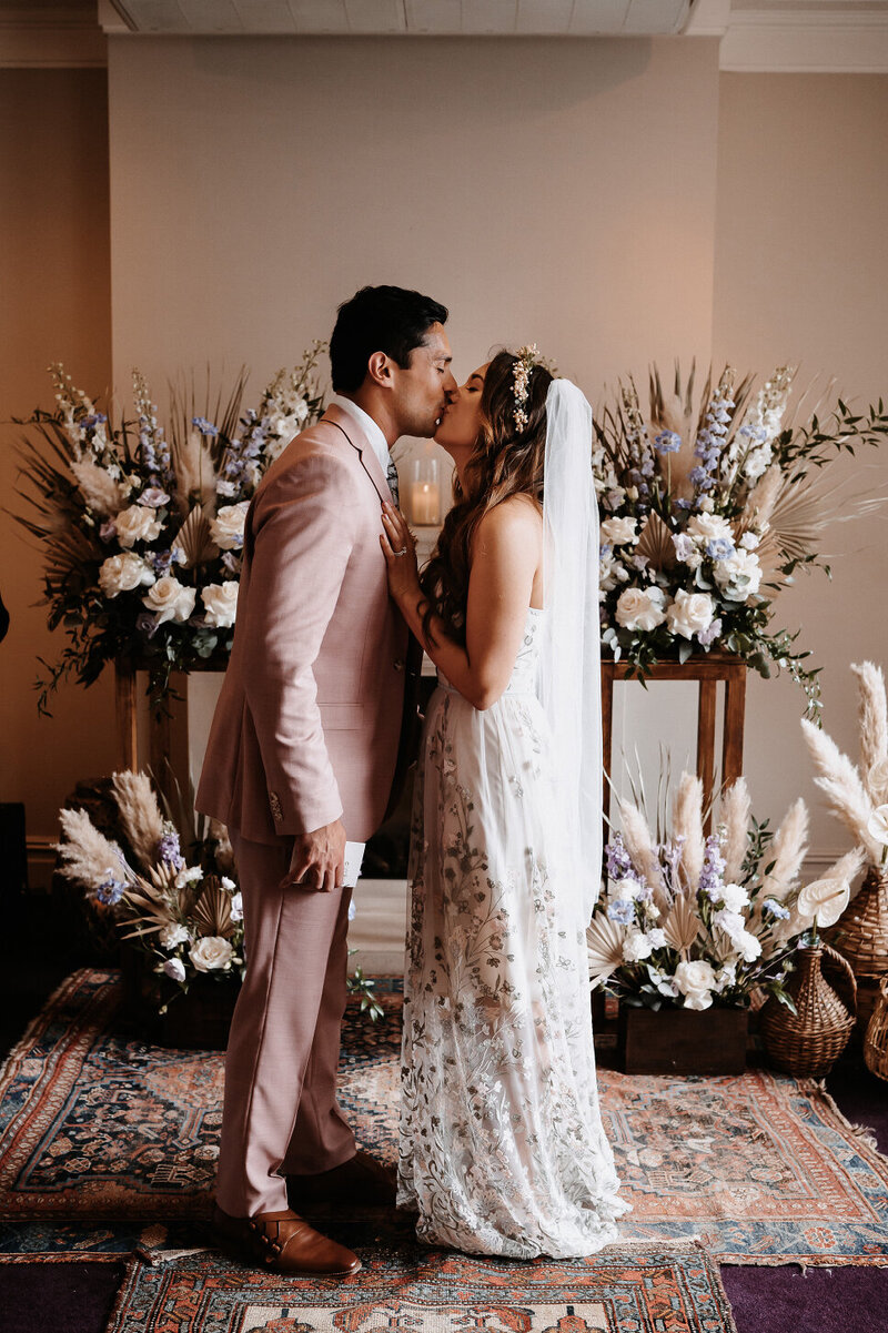 bride-kissing-groom-surrounded-by-flowers