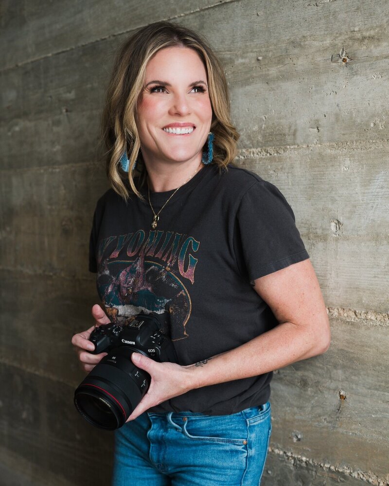 Sarah smiling while holding a camera