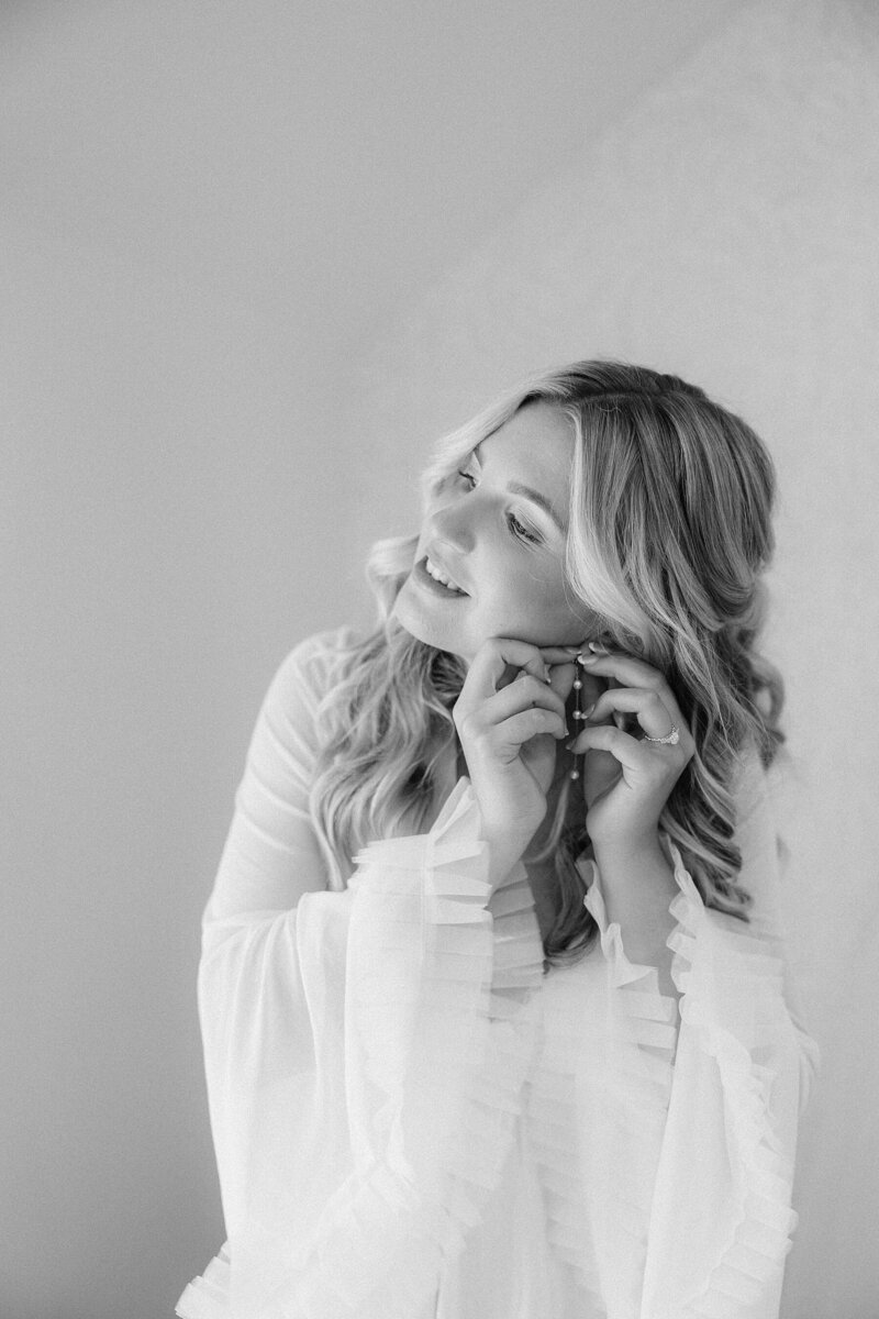 Grace putting on her earrings, photo taken by a Black Hills Photographer.