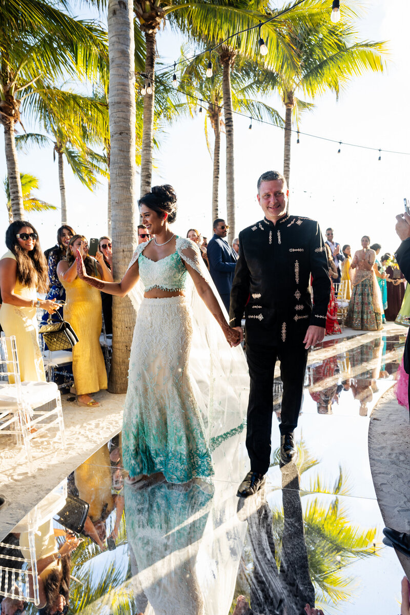 San Francisco Bay Area wedding photographer captures destination ceremony as bride and groom walk down aisle in Florida Keys with palm trees and tropical setting