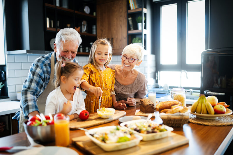 grandparents smiling with grandchildren in kitchen