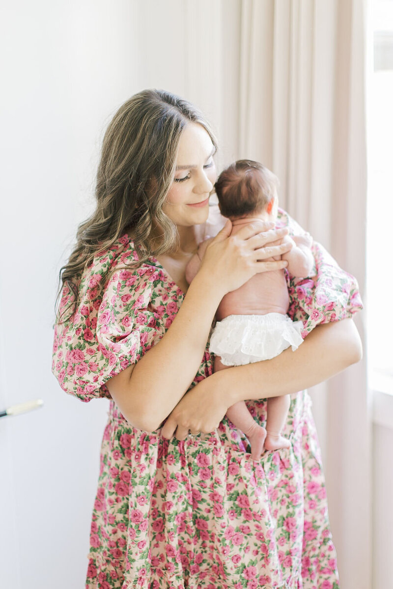 Outdoor senior portrait of a girl in a cream dress and cowboy boots walking along a wooden fence, captured by Raleigh Senior Photographer Lindsey Lambert Photography.