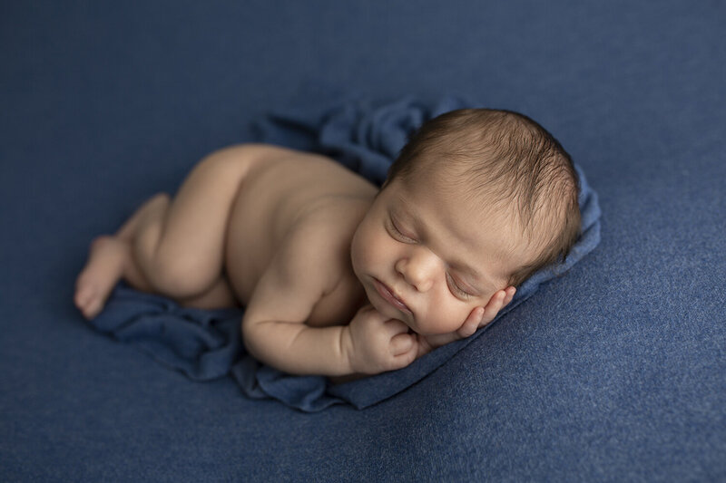 newborn sleeping on blue