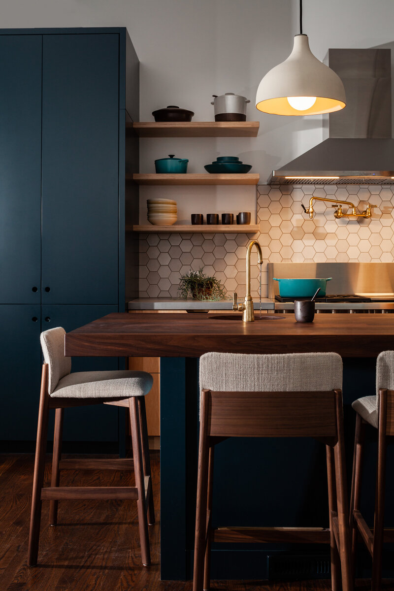 Interior brand photography of a contemporary kitchen with dark cabinets and open shelves.