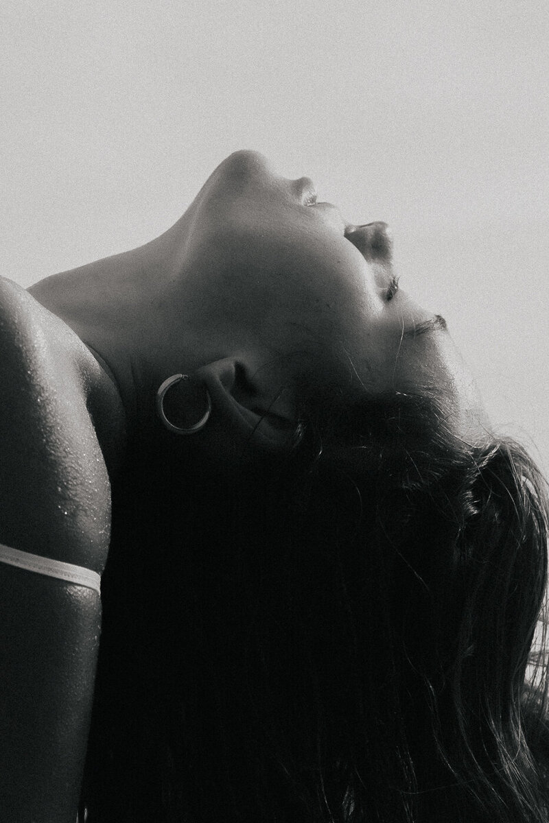 lack and white photo of a woman lying back with her hand near her face, used as cover for aesthetics clinician case study
