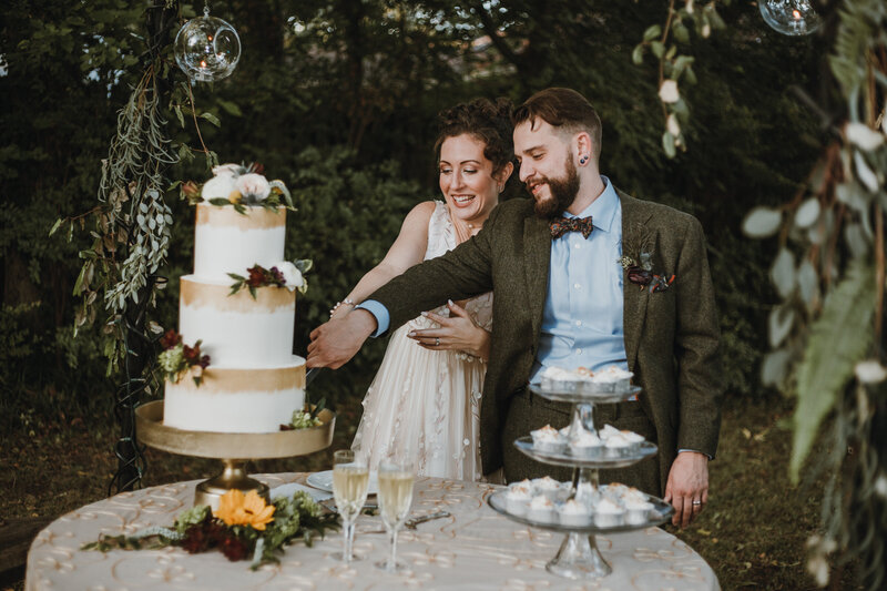 bride and groom cutting white wedding cake