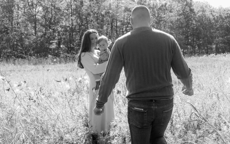 Real life family photography session in a grassy field showing connection and joy