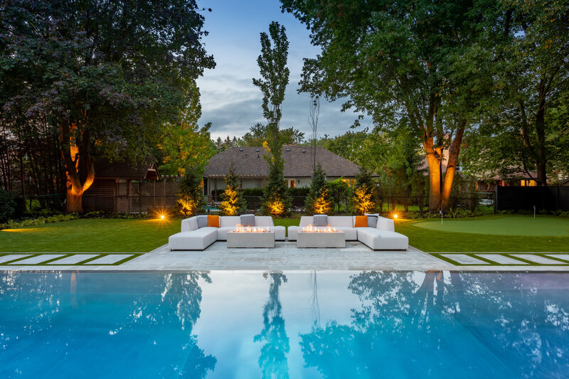 infinity pool with a white lounge area and ground mounted spotlights