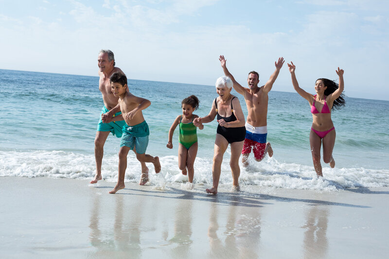 multi-generation-family-running-beach