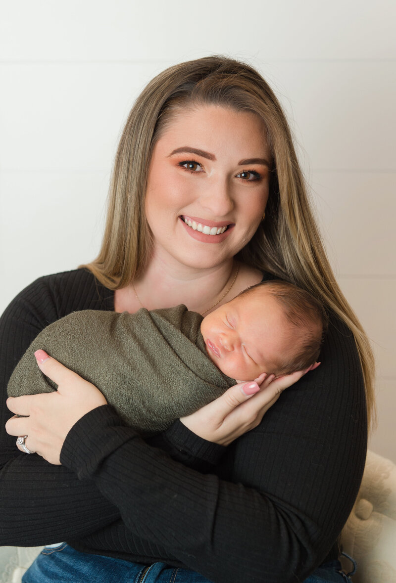 Newborn baby boy swaddled and taking first portrait with Mom.