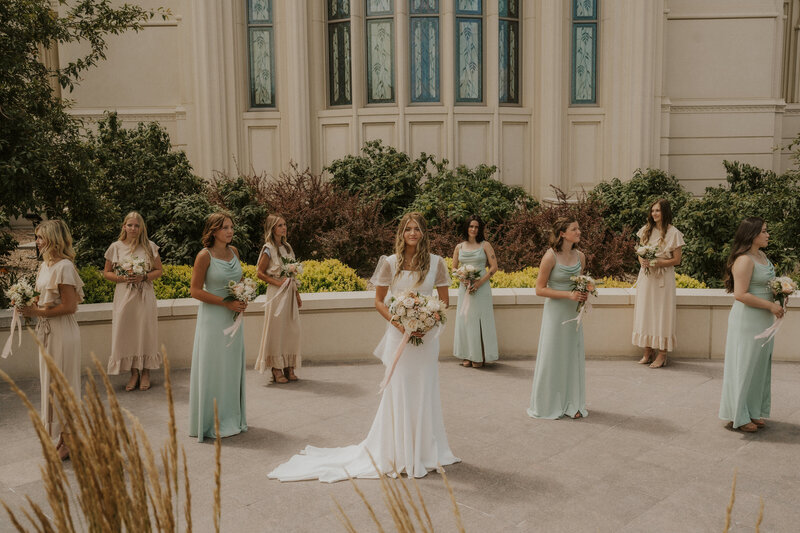 Bridesmaids stand together with bride in front of Payson Temple