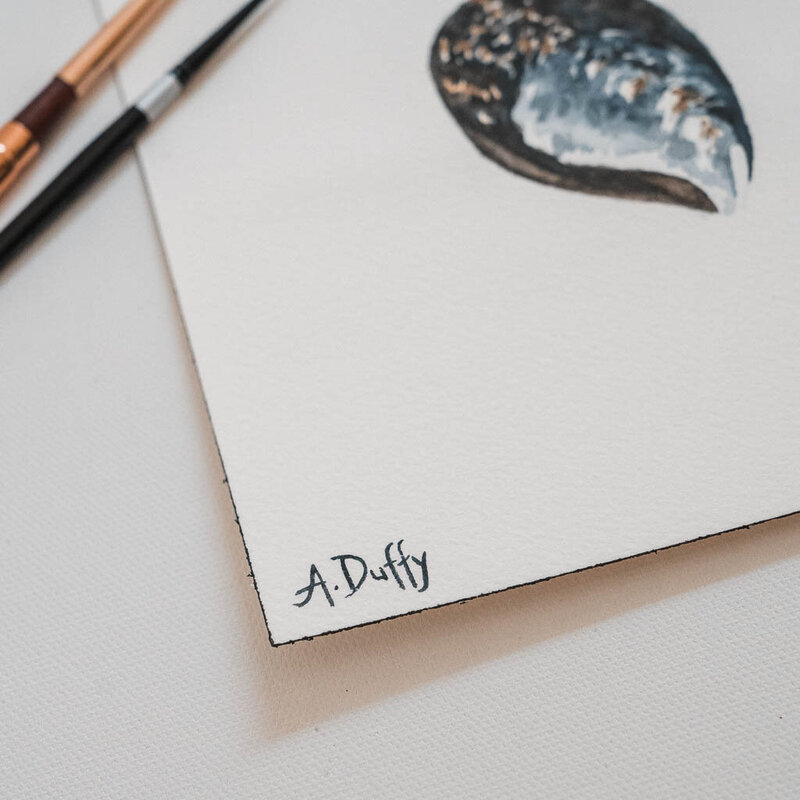Signature of artist Amy Duffy on a paint of blue mussel shells