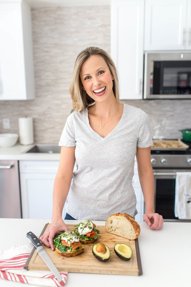 Headshot of Amanda Miller in kitchen with avocado toast.