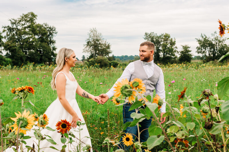 Bride and groom walking in sunflower wildflower field Newark Ohio