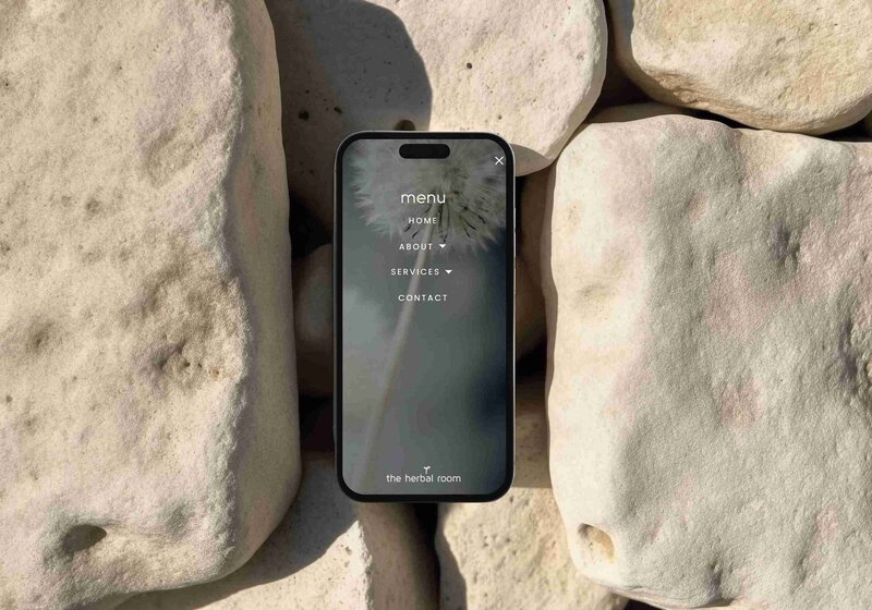 Mockup of an iPhone Pro Max displaying a holistic website design on its screen.