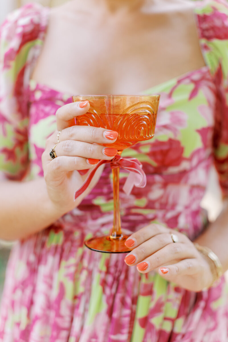 Eleanor Stenner wearing colorful dress and holding orange glass for styled shoot Alabama