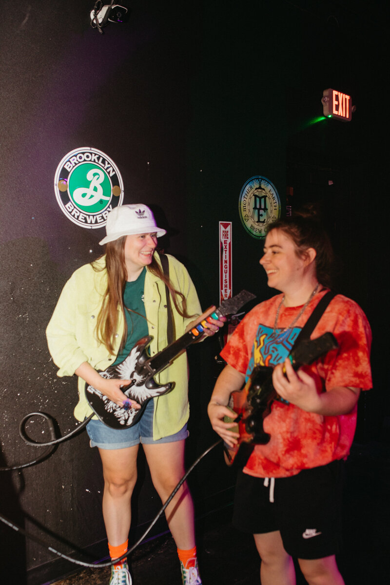 two girls playing guitar hero