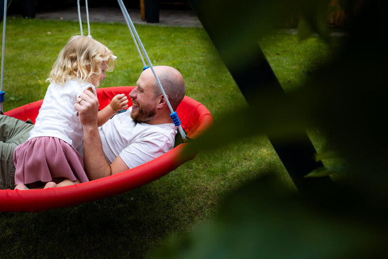 vader en dochter spelen in schommel