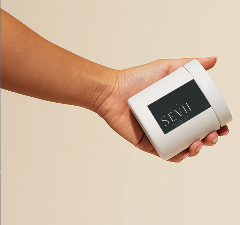 Someone holding the Hello Sevii candle product