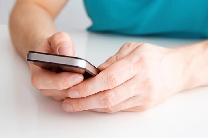 Author's hands using smartphone for book marketing and promotion services