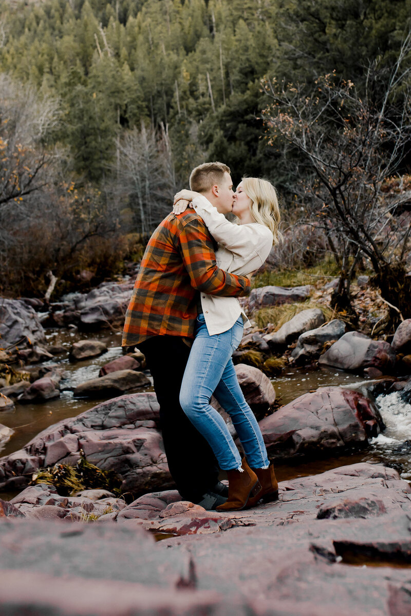 couple sitting on rocks kissing
