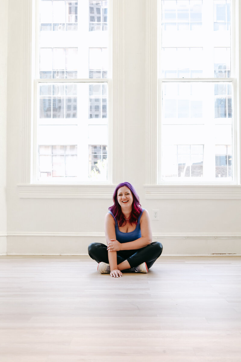 Photography Coaching | Karinda K | Karinda sitting on the floor of an empty white room