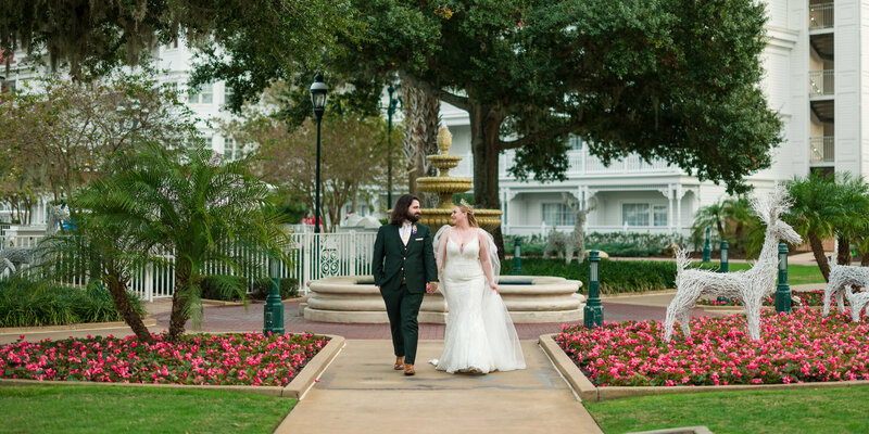 Bride and groom walking the picturesque grounds of the Grand Floridian Hotel, capturing the elegance of their Disney wedding.