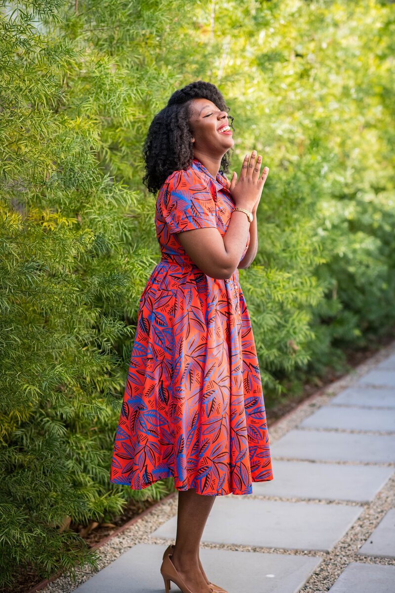 Krystal laughing in a red and purple floral dress