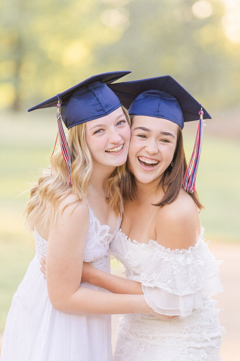 high school best friends wearing graduation cap laughing during senior photos in Loudoun County, Virginia