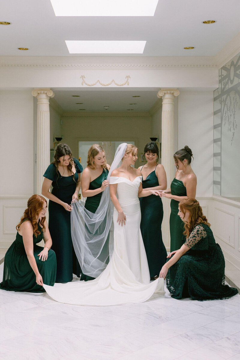 Picture-perfect bridesmaids rocking elegant green dresses and stunning white veils, adding a touch of enchantment to the wedding day