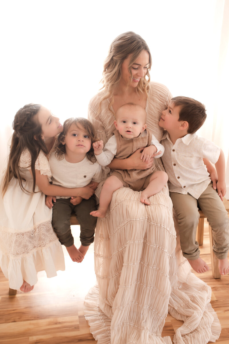 Mother of four sitting on a bench with her children.