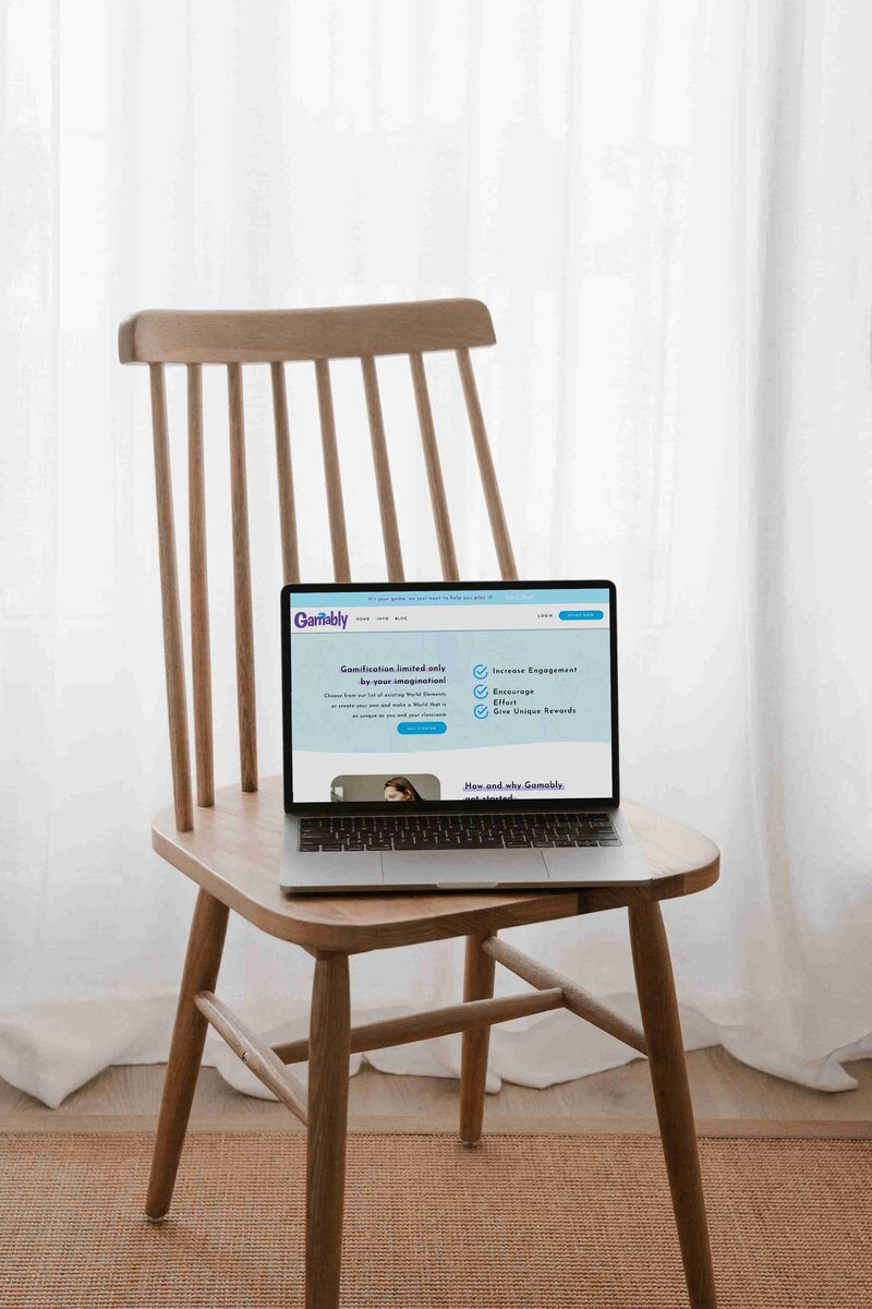 A laptop sits on a wooden chair, ready for interactive learning in a gamified classroom setting.