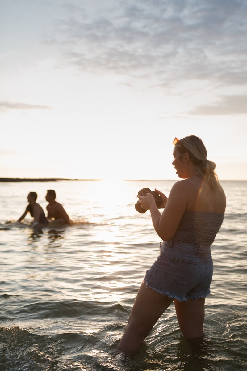 girl standing on beach with camera