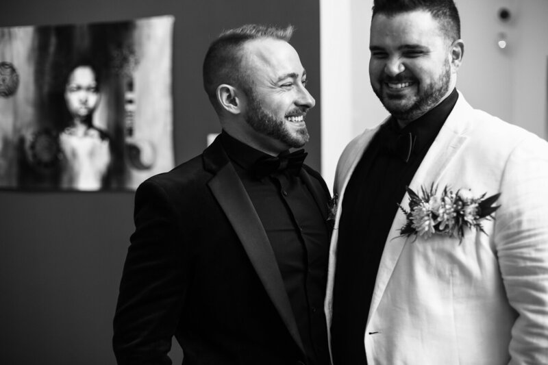 Two smiling grooms at Erie Art Museum wedding