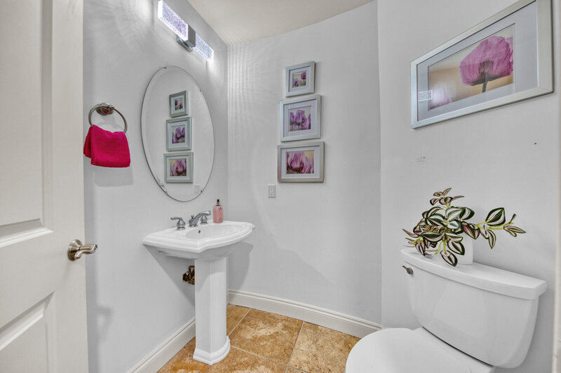 bathroom with pedestal sink and oval mirror